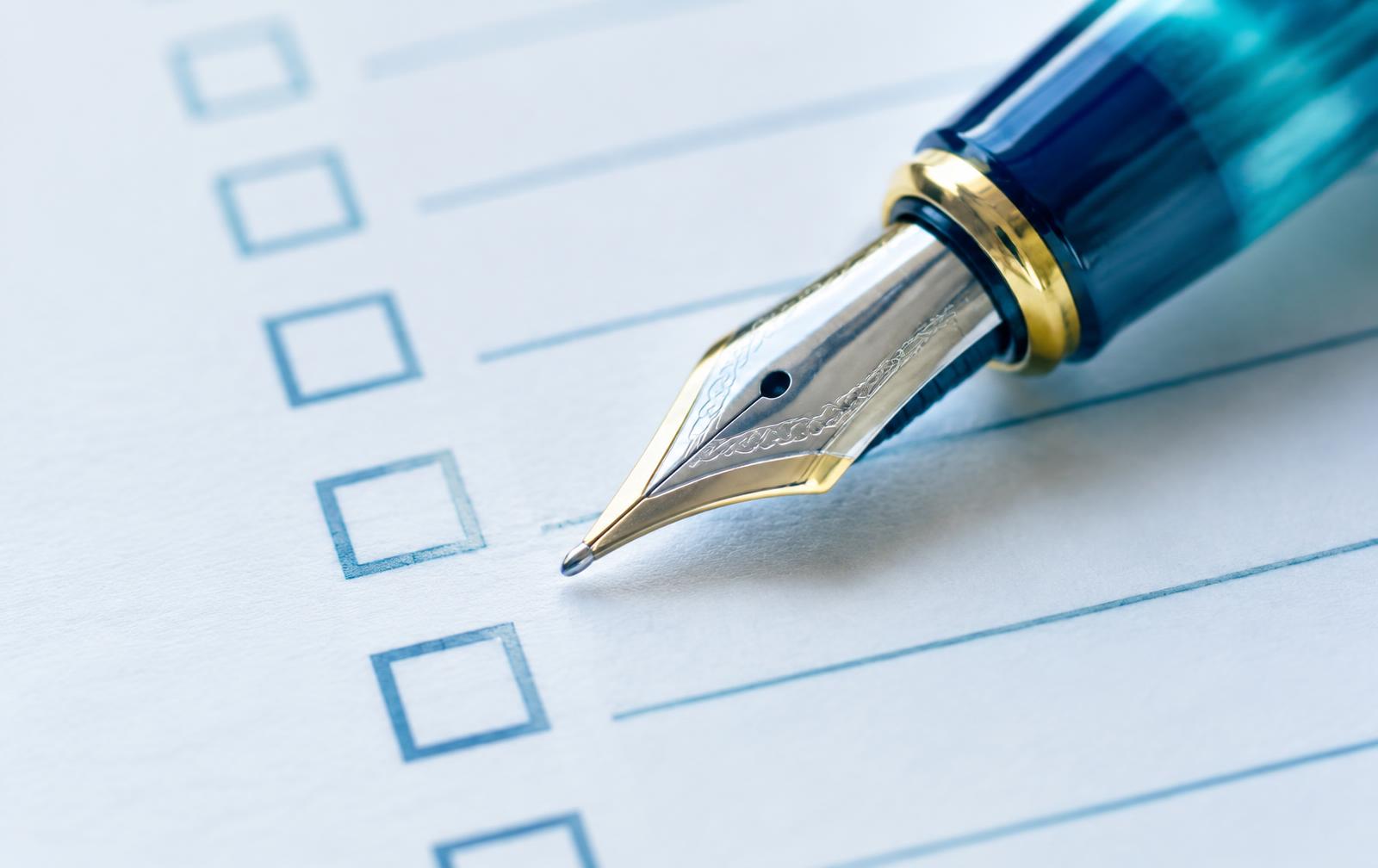 Close-up of a pen tip resting on a printed checklist