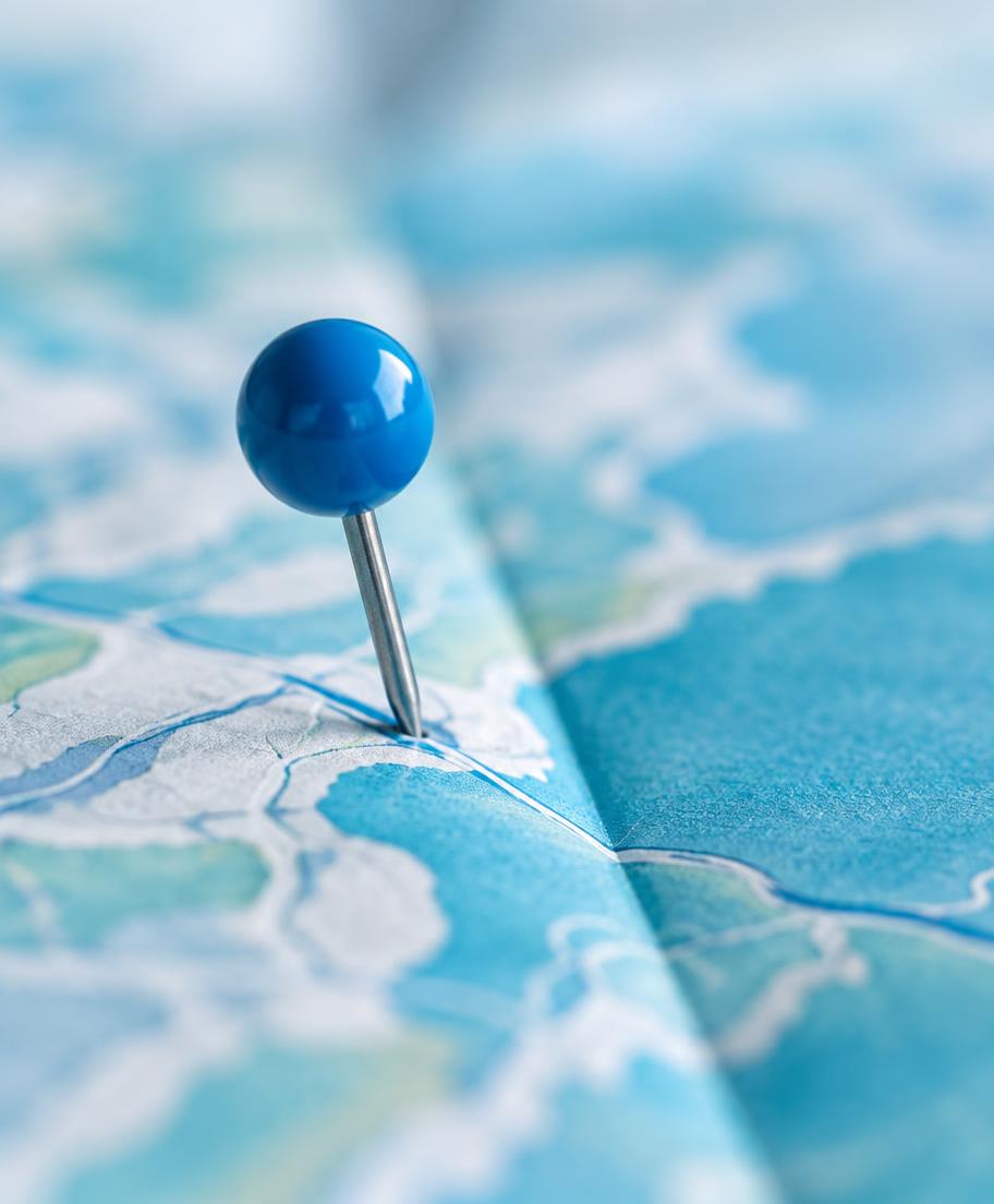 Blue pin marking a spot on a paper map